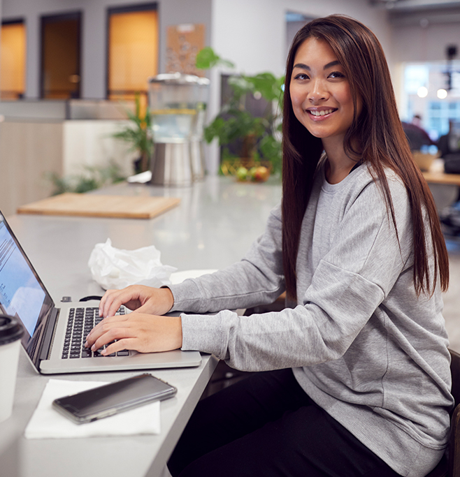 additional-benefits Employee smiling in an office workspace